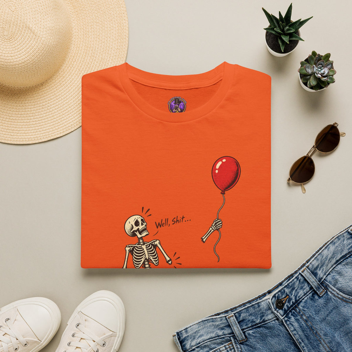 Well Shit Skeleton Balloon Halloween shirt laid flat with jeans and accessories.