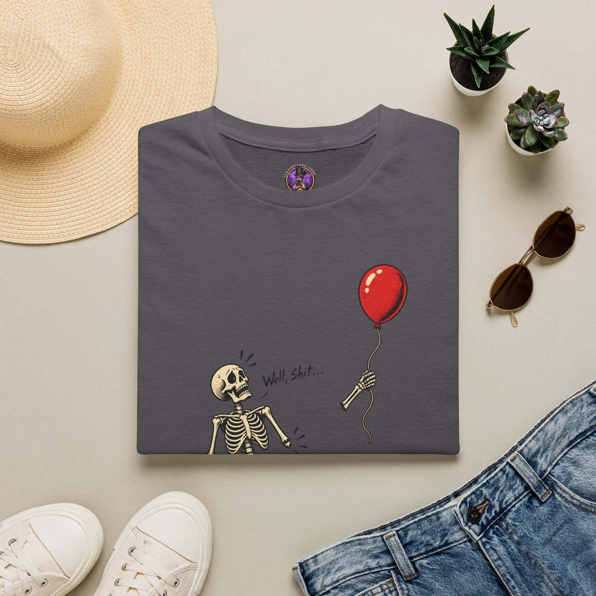 Well Shit Skeleton Balloon Halloween shirt laid flat with jeans and accessories.