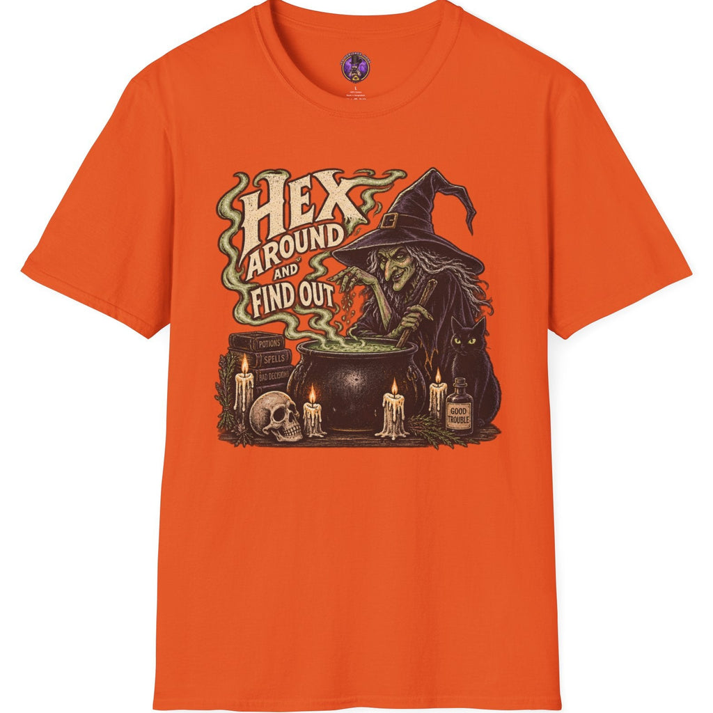 An orange short-sleeve crewneck t-shirt featuring a Halloween graphic of a witch stirring a cauldron with the text 'HEX AROUND ME TO FIND OUT'.