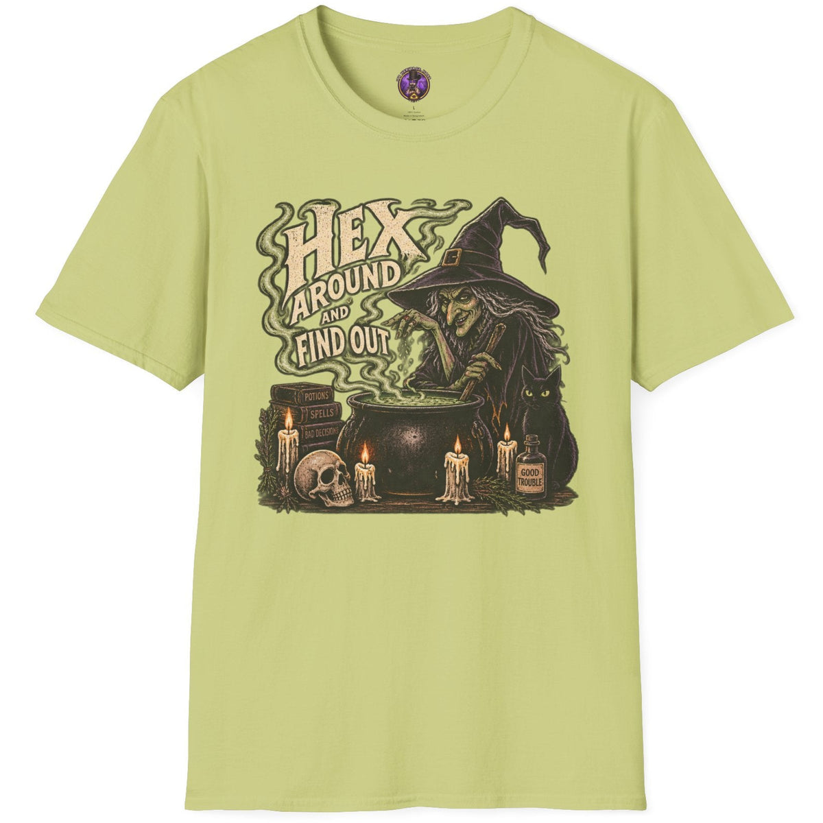 A light yellow-green crewneck t-shirt featuring a dark graphic of a witch by a cauldron with the text 'HEX AROUND ME AND OUT'.